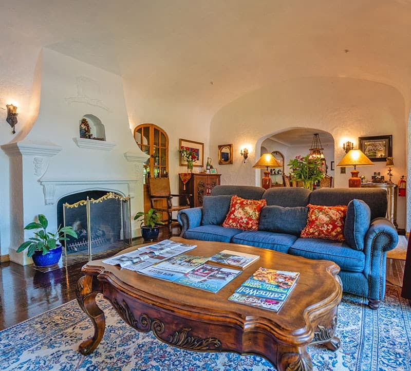 Cozy living room featuring a blue sofa with red cushions, a wooden coffee table, and a fireplace.