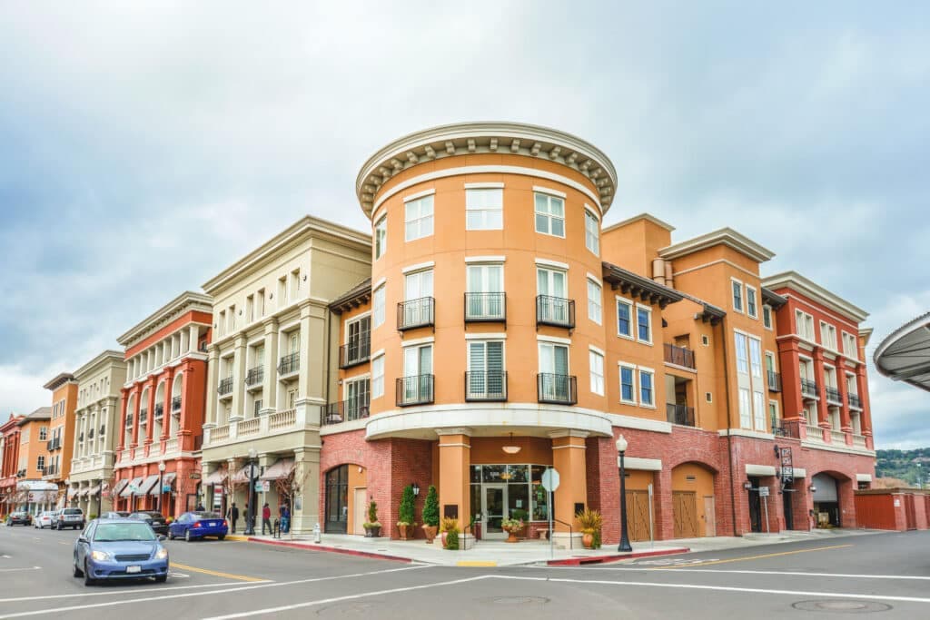 A corner view of a modern, multi-story building featuring a mix of brick and stucco architecture.