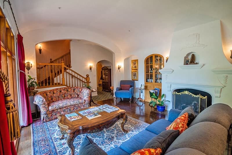 Cozy living room with patterned sofas, a coffee table, and a staircase leading to the upper level.