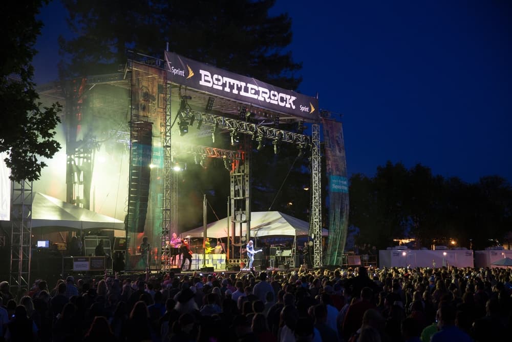 A large crowd enjoys a live performance at the Bottlerock music festival at night.