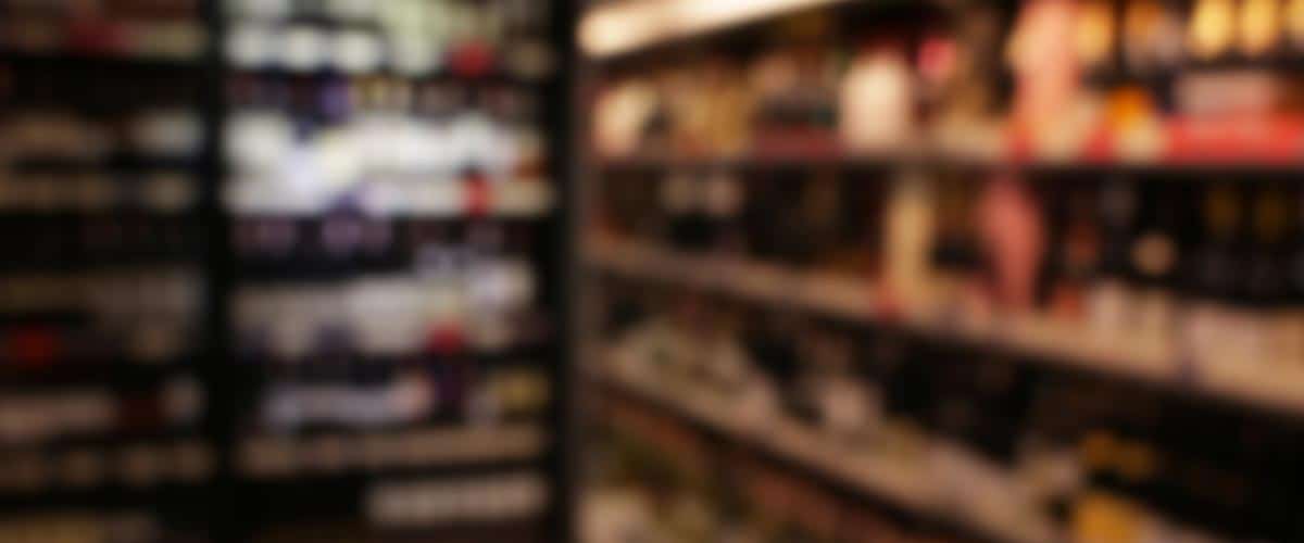 Blurred image of shelves lined with various bottles and beverages.