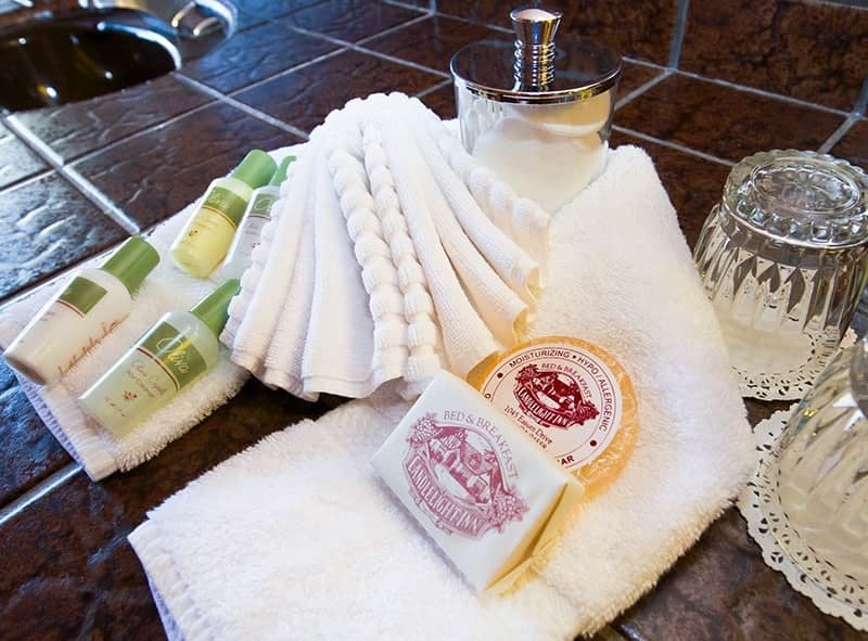 A neatly arranged collection of spa toiletries, including small bottles, a bar of soap, and soft towels.