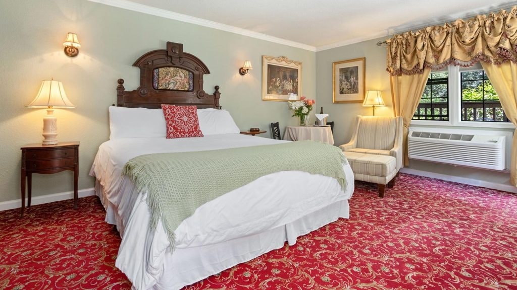 Cozy hotel room featuring a king-sized bed, elegant decor, and a small seating area.